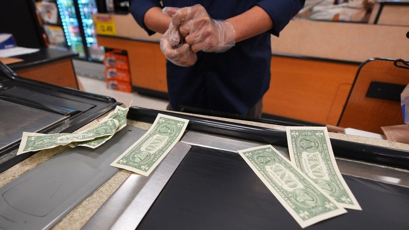 A grocery store cashier pauses while pulling dollar bills for their cash drawer in Dallas, Wednesday, April 15, 2026. (AP Photo/LM Otero) TXMO111
