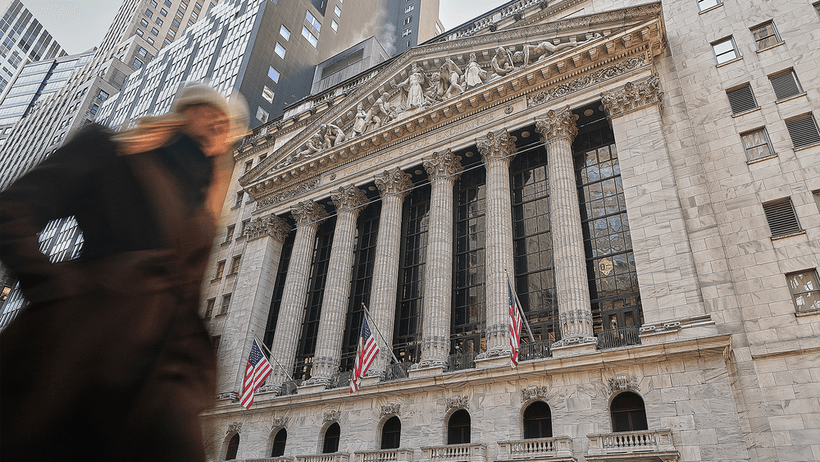 En person vandrar för New York Stock Exchange på Wall Street i New York. 